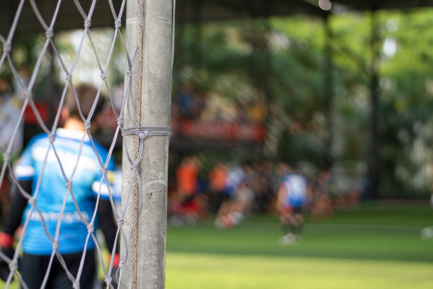 Soccor球门网与亚洲学校的孩子们在足球与年轻的男孩球员在足球比赛场地在体育俱乐部作为背景。图片下载