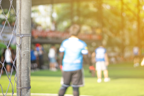 Soccor球门网与亚洲学校的孩子们在足球与年轻的男孩球员在足球比赛场地在体育俱乐部作为背景。图片下载