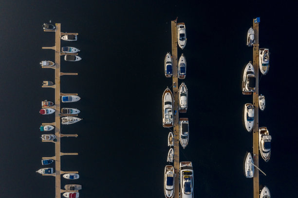 船只、游艇、帆船和其他船只停泊在河堤上。航拍水上停泊船只的无人机。图片下载