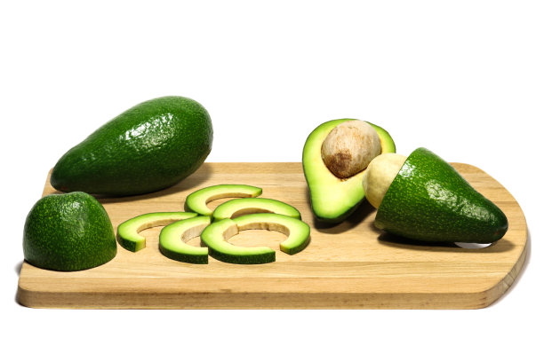 一个白色鳄梨在切菜板上的孤立照片。美味和健康的水果的背景和整体。图片下载