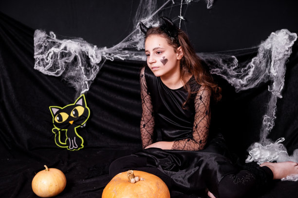 女孩穿着万圣节服装，背景是黑色。图片下载