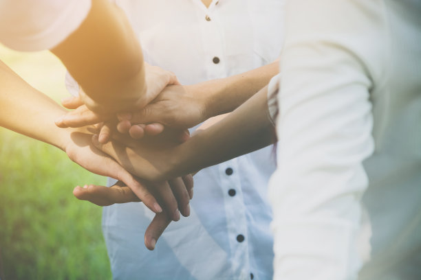 团队合作企业携手共进的理念，力量的志愿慈善工作，堆叠人的手图片下载