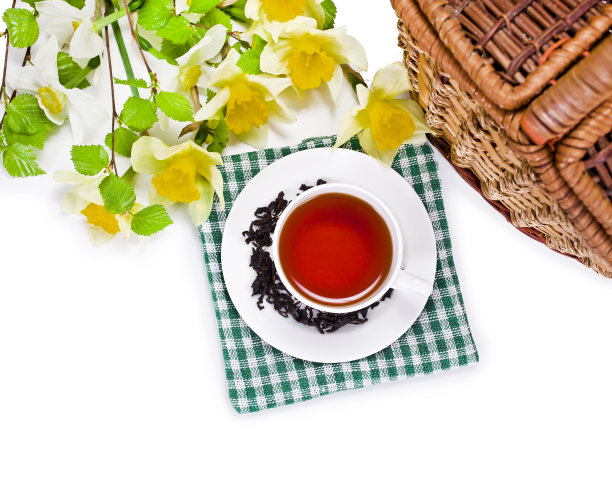 春天的静物画。红茶与黄色的水仙花，绿色的桦树树枝和柳条篮子图片下载