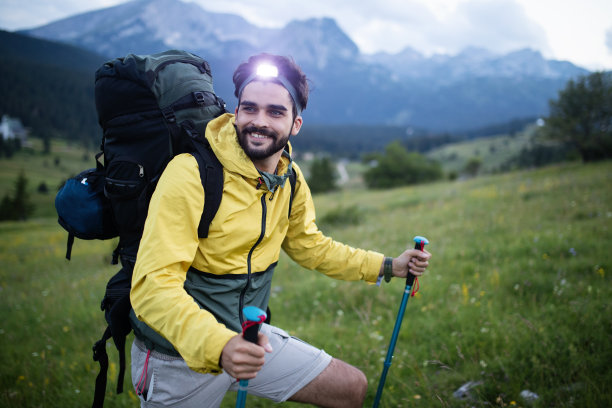 背包和登山杆的徒步青年在户外看山素材图片
