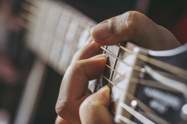 女性手弹吉他的特写图片下载