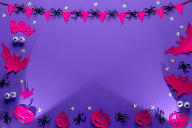 创意万圣节框架在紫色，红色和黑色，平躺与复制空间。巧克力眼睛、蝙蝠、南瓜灯、星星、旗帜花环和蜘蛛的纸工艺品。图片下载