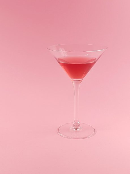 粉红背景上的红马提尼酒杯图片下载