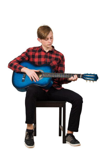 完整的长度肖像的天才男孩少年玩的原声吉他坐在椅子上孤立的白色背景。让学生成为著名的音乐家的伟大的音乐课。图片下载