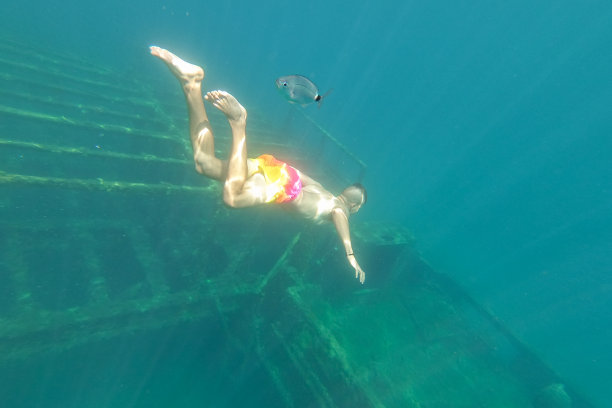 克罗地亚扎夫拉特尼察，一名潜水员在水下看着沉船，一艘沉没在海底的老船图片下载