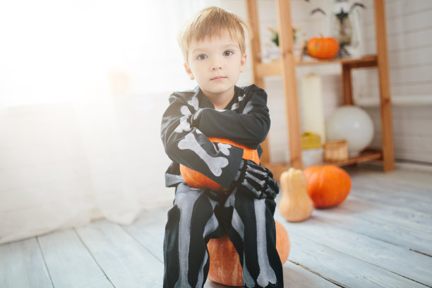 穿着骷髅装的小男孩准备庆祝万圣节。万圣节化妆室里的男孩。图片下载