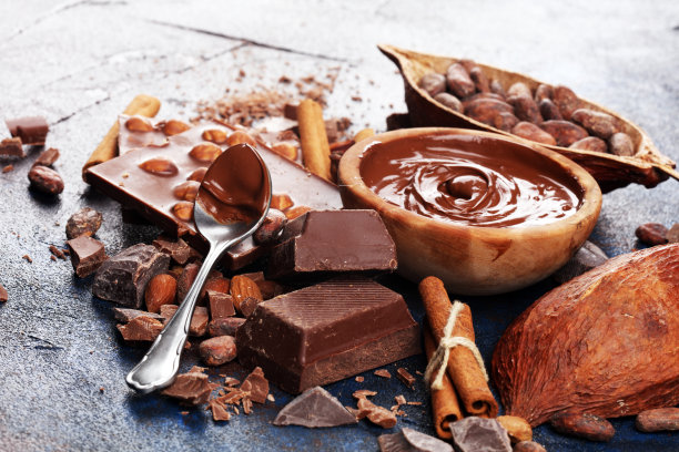 巧克力块和融化的漩涡可可。甜食照片的概念。桌上的大块碎巧克力图片下载