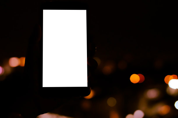 手持移动智能手机与散景夜灯图片下载