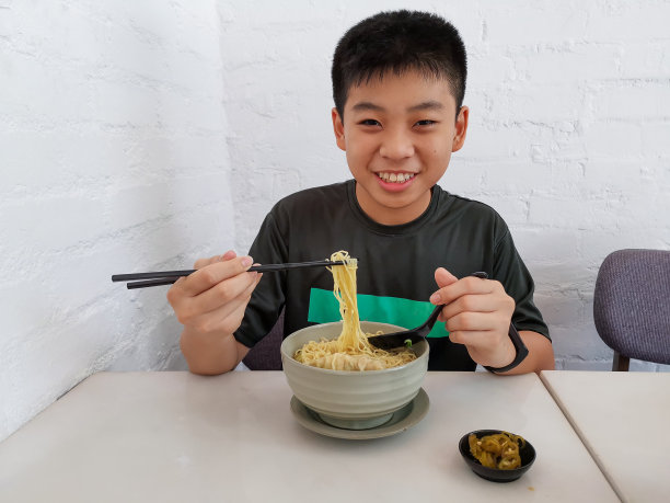 亚洲男孩在餐厅享受典型的亚洲食物图片下载