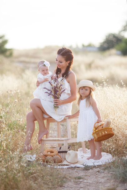 年轻快乐的母亲和两个年幼的孩子花时间在野外的乡村。图片下载