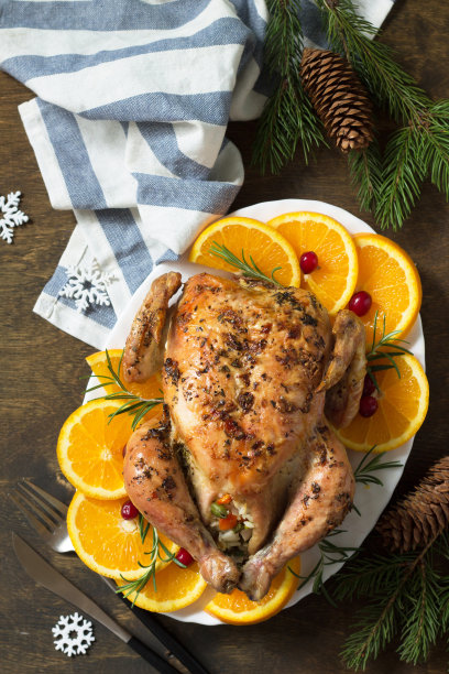 圣诞节的传统节日食品。塞满米饭和蔬菜的圣诞火鸡放在木桌上。前视图。图片下载