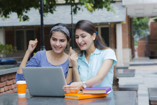 惊讶的学生在笔记本电脑库存照片上得到考试成绩图片下载