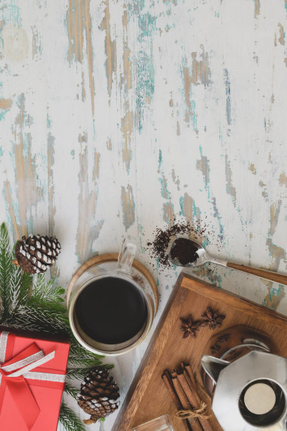 顶视图的圣诞装饰工作场所的咖啡杯和礼物在古董木书桌上图片下载