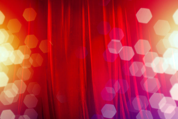 舞台上的红色窗帘与散焦灯光背景素材图片