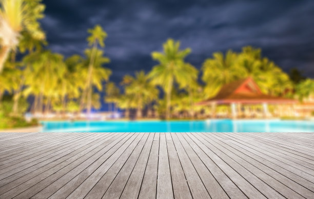 晚上热带游泳池旁的木制平台图片下载