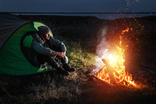 野营的人坐在火边，对着天空。旅游、旅游、露营的概念。图片下载