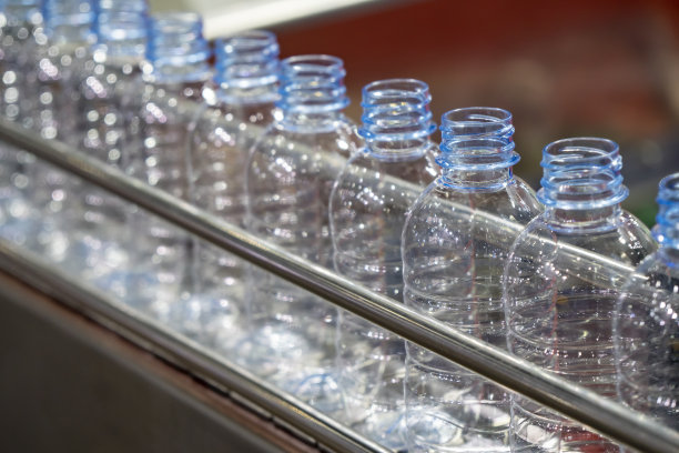 PET瓶在输送带上用于饮用水工厂的灌装过程。图片下载