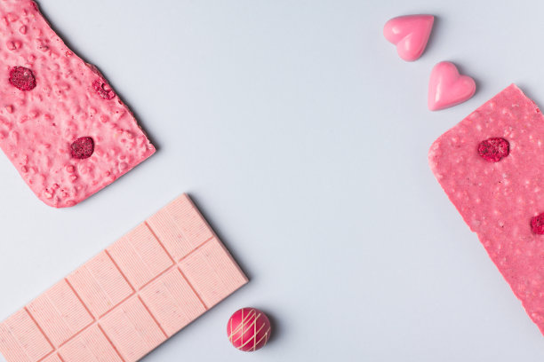 一块粉红色的巧克力平放在蓝色的背景上图片下载