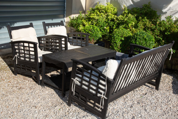 房子的阳台上放着黑色的花园家具和靠垫图片下载