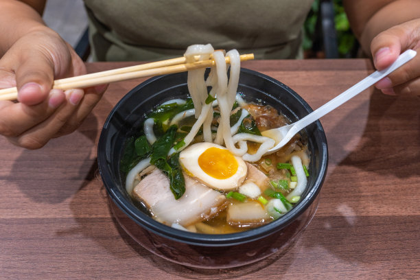 人手用筷子夹乌冬面的特写照片图片下载