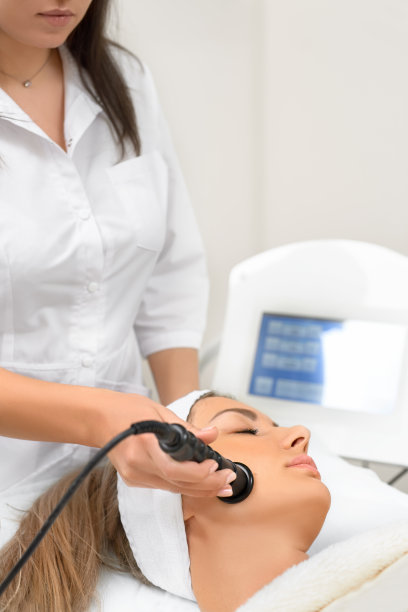 面部皮肤护理。年轻漂亮的黑发女子在美容院接受治疗。图片下载