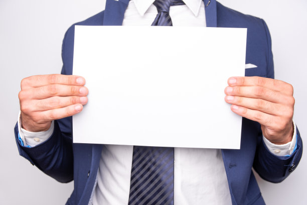 一个穿蓝西装拿着白牌的人。图片下载