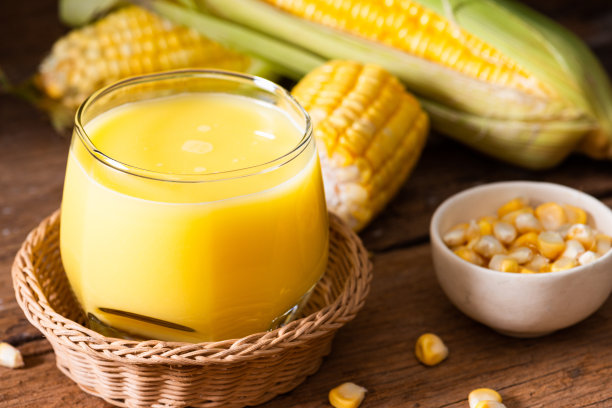 新鲜甜玉米汁(玉米奶)和玉米在木材背景图片下载
