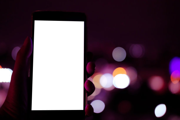 手持移动智能手机与散景夜灯图片下载