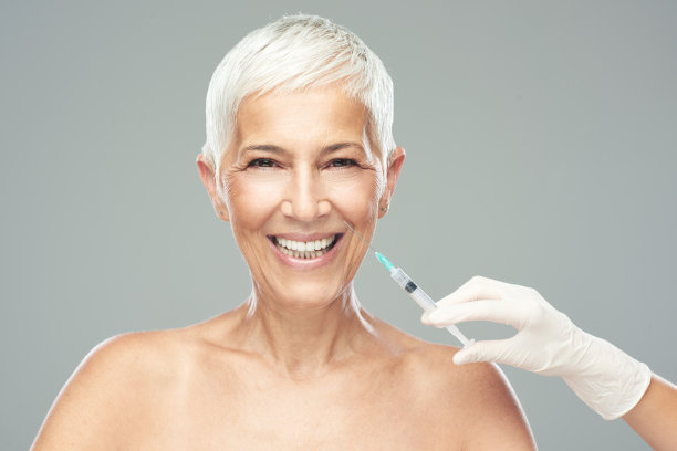 老年妇女服用抗衰老产品的一针。素材图片