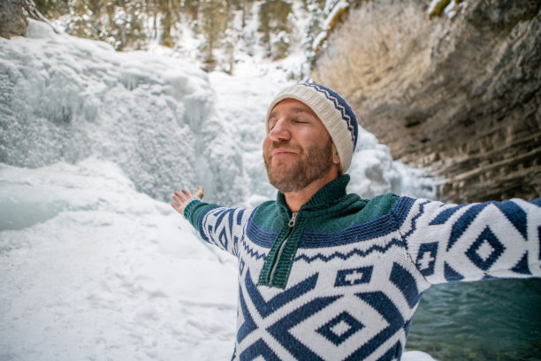 年轻人在冰洞里伸开双臂享受冬天图片下载