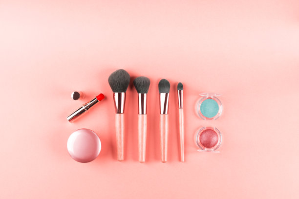 把化妆用品和化妆刷涂成粉色。平躺图片下载