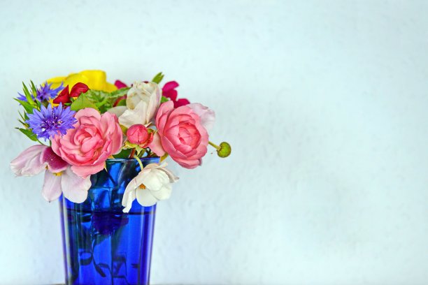 蓝色玻璃杯里的一小束花。可以作为贺卡使用。巴伐利亚,德国。图片下载