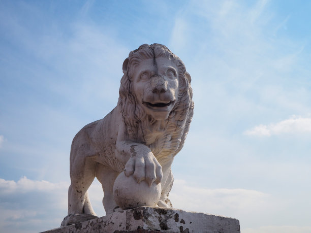 城市公园河岸上的白色石狮雕塑图片下载