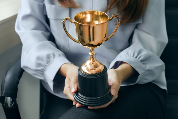 女商人手中的金杯，成功的理念。图片下载