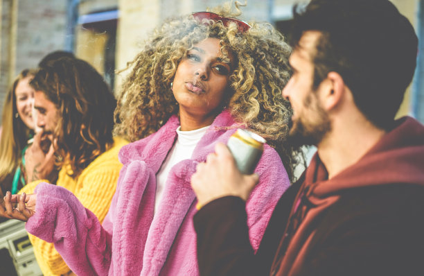 来自不同文化的时尚人士参加户外聚会，喝啤酒，抽烟，听音乐-年轻的朋友在一起玩-节日和周末的概念-关注非洲女孩的脸图片下载