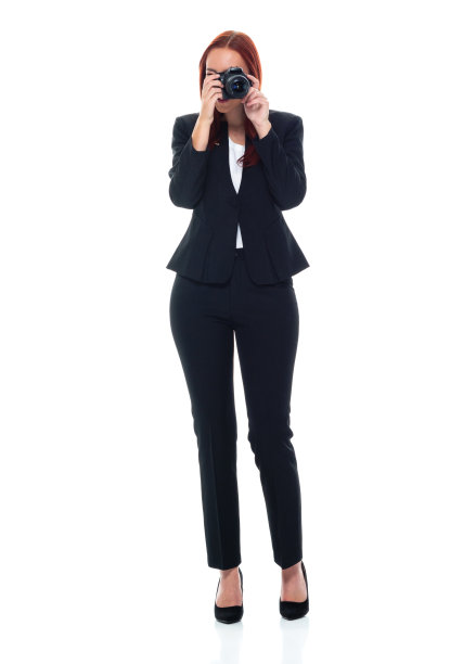 全身/正面/看着相机/一个人20-29岁的成年人漂亮的红发/长发白种人女性/年轻女性摄影师/摄影/游客/女商人/商人站着穿着商务装图片下载