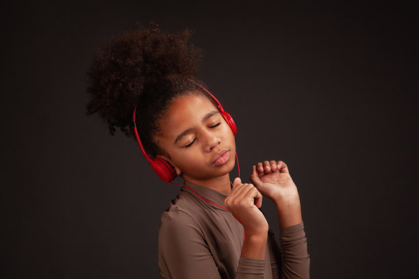 可爱的女孩戴着红色耳机听音乐图片下载