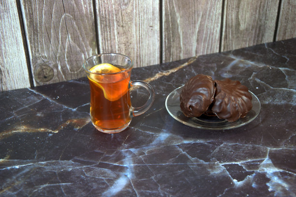 一杯茶，杯中放着一片柠檬和两块巧克力棉花糖。图片下载