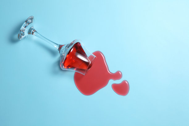 红酒洒在蓝色背景上，文字空白，红酒洒在彩色桌上图片下载