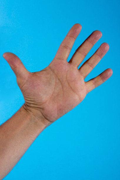 男性的手掌在蓝色背景上展开图片下载