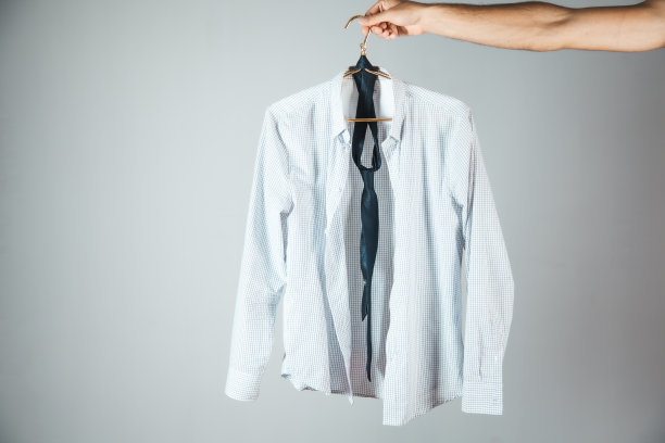 衬衫挂在男手上。在灰色背景图片下载