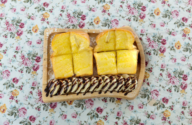 吐司上加甜炼乳和巧克力粉。烤面包，黄油和炼乳放在盘子里。俯视图的早餐，巧克力，果酱，干吐司面包，黄油和牛奶。图片下载