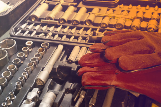 汽车修理工具包。焊接用的红色手套放在工具上。维修和保养的概念。梯度的照片。图片下载