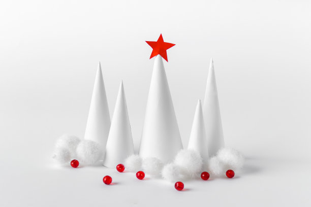 白色的圣诞树上装饰着红色的球和红色的星星图片下载