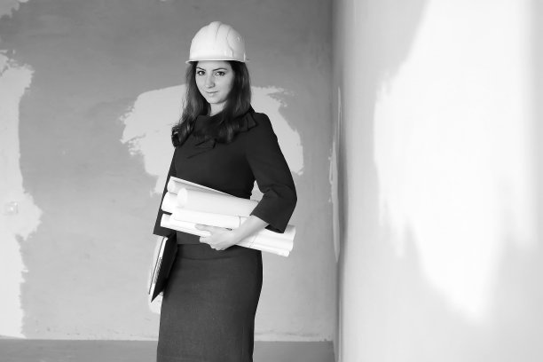 一名女建筑师在工地上的黑白照片，带着图纸和笔记本图片下载