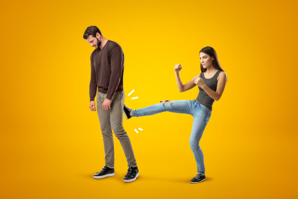 年轻的黑发女孩穿着休闲牛仔裤和t恤踢悲伤的年轻人在黄色的背景休闲衣服图片下载